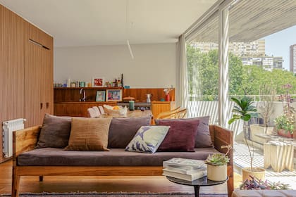 Sillón y almohadones hechos a medida con proveedores del estudio (Malva Arquitectura). Plantas (Tou Tou Galpón). Al fondo, el revestimiento varillado ‘Novel Wall Panel’ (The Flooring Company) deja oculta la heladera.