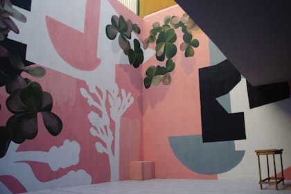 Siluetas abstractas y motivos botánicos figurativos se combinan en esta obra que realizó la artista Sofía Mele, en colaboración con Hernán Wave y Sisa Soldati. Los tonos pasteles con algo de presencia de negro dan sensación de mayor amplitud.
