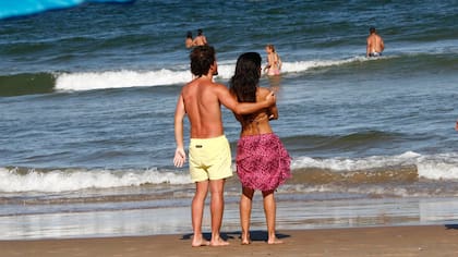 Silvina y su misterioso acompañante, abrazados y mirando el mar