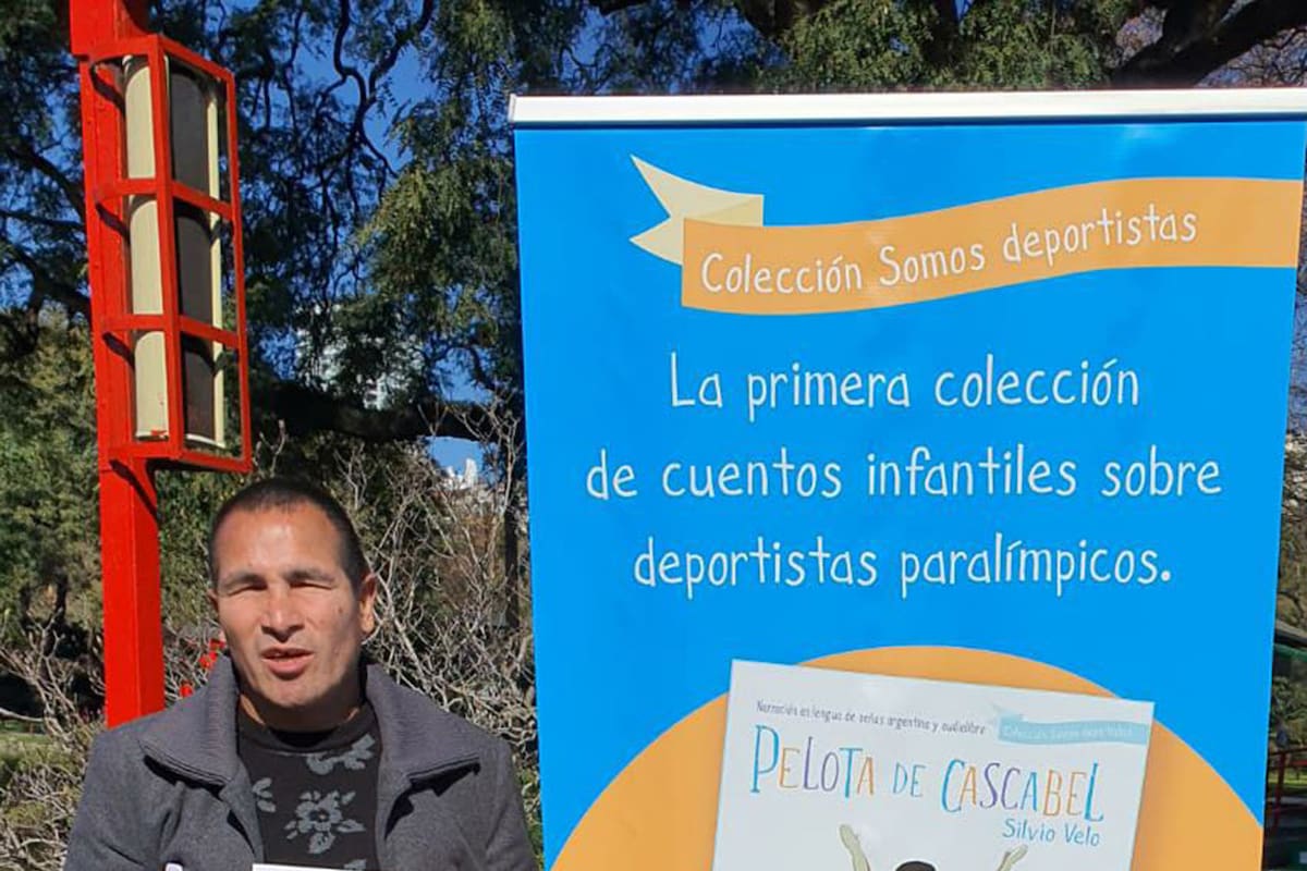 Silvio Velo, un histórico de los Murciélagos, posa con un ejemplar del cuento infantil que narra su historia: "Pelota de Cascabel"; el libro integra la colección "Somos deportistas", presentada este viernes en el Jardín Japonés.