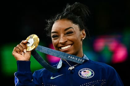 Simone Biles posa con su medalla de oro durante la ceremonia del podio después de la final del concurso completo femenino de gimnasia artística durante los Juegos Olímpicos de París 2024. (Photo by Loic VENANCE / AFP)