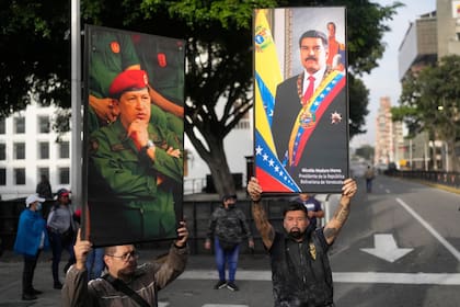 Simpatizantes chavistas levantan carteles de Chávez y Maduro este sábado en Caracas.
