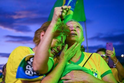 Simpatizantes de Jair Bolsonaro se abrazan mientras escuchan los resultados parciales después del cierre de urnas en la segunda vuelta de las elecciones presidenciales en Brasilia, Brasil, el domingo 30 de octubre de 2022.