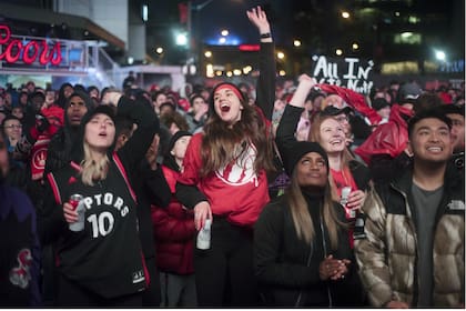 Simpatizantes de Toronto Raptors siguen los partidos de su equipo mediante pantallas gigantes fuera del estadio; la única franquicia no estadounidense de la NBA tiene mucho arrastre en la ciudad canadiense.