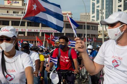 Simpatizantes del gobierno asisten a una caravana "por el amor, la paz y la solidaridad", organizada por la Unión de Jóvenes Comunistas en La Habana, Cuba, el jueves 5 de agosto de 2021. (AP Foto/Ismael Francisco )