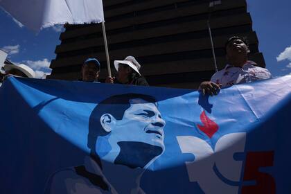 Simpatizantes del movimiento Revolución Ciudadana llevan una pancarta con una imagen del expresidente Rafael Correa