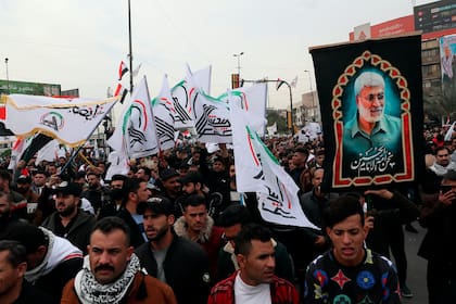 Simpatizantes y miembros de las Fuerzas de Movilización Popular efectúan el sábado 1 de enero de 2022 una protesta en Bagdad en el aniversario del asesinato del general iraní Qassim Soleimani y el subcomandante de ese grupo armado, en un ataque con dron lanzado por Estados Unidos. (AP Photo/Khalid Mohammed)