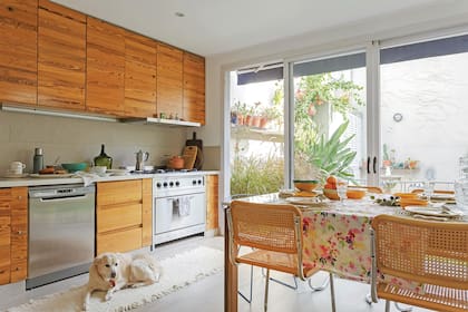 Sin herrajes, el mueble de cocina fue concebido por el dueño de casa como una pared de madera que exalta las vetas de la pino tea. Una nueva tendencia que reúne calidez y fácil mantenimiento: pisos cementicios imitación madera (Portobello).