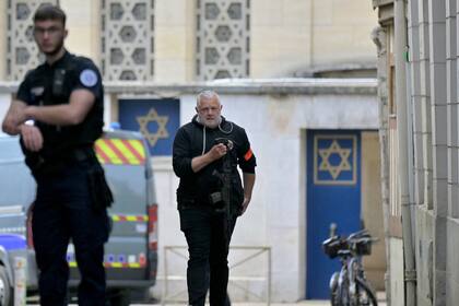 Un policía sostiene un rifle mientras pasa por la entrada de una sinagoga donde la policía francesa mató a un hombre armado que había intentado incendiar el edificio