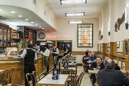 Sobre el final del salón, el vitral de colores hace honor al campanario de La Giralda, la torre de la catedral de Sevilla que le dio el nombre al café