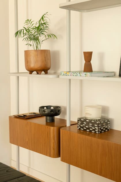 Sobre esa base de la mesa y sillas de comedor se armó una biblioteca con módulos de petiribí natural y estructura de herrería terminada con hidrolaca mate.