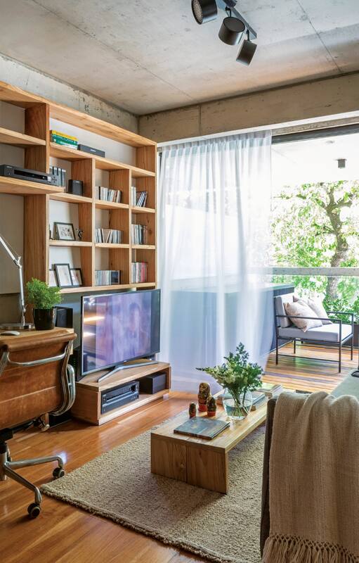El sofá tapizado en lino de 2x0,90m se divide en dos. Es bajo, para no invadir el espacio y teniendo en cuenta la altura de la TV, que el dueño quiso ubicar en un lugar con poco protagonismo. Alfombra de pura lana (Elementos Argentinos). Jarrón con flores (Otra Sudestada Flores).