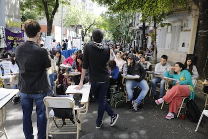 Sobre la calle Santiago del Estero, cortada al tránsito con cintas de peligro y pupitres, se dictan al menos 15 clases a la vez a los alumnos de la Facultad de Ciencias Sociales