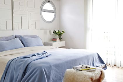 Sobre la cama, un panel corredizo de placas de madera pintadas que se luce casi como un cuadro y sirve de persiana para las claraboyas. Funcionalidad y diseño en un solo movimiento.