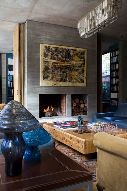 Sobre la chimenea, obra de Eduardo Hoffmann. Lámparas con forma de hongo (Estudio Ilusión). Corderito sobre banqueta (Fez). Iluminación colgante (Vantier Home & Deco).