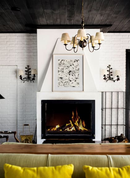 Sobre la chimenea, un pattern de textiles de un artista francés se enmarcó sobre blanco. Los apliques son un hallazgo de un mercadillo de Uruguay