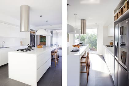 Muebles e isla laqueados en blanco (Sergio Ruiz) con mesadas de material sintético ‘Blanco Sydney’ (Mármoles Dodera). Campana cilíndrica (Franke), lámparas colgantes (Lumishop), banquetas altas (Talleres Sustentables).