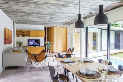 Sobre la mesa, individuales de fibras naturales y servilletas de algodón (Claudia Adorno). Equipada para 6 o 7 personas, esta vivienda se alquila en cualquier momento del año por Airbnb.