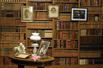 Sobre la mesita, las camelias de "Santa", su esposa. Su centenaria planta, la que ella cuidaba, está en el patio y los azuleños acostumbran colaborar con la biblioteca comprando sus flores en temporada. A la izquierda, un retrato de Santa (María de las Nieves), y en el centro, uno de Margarita Ronco, fallecida a los 15 años.