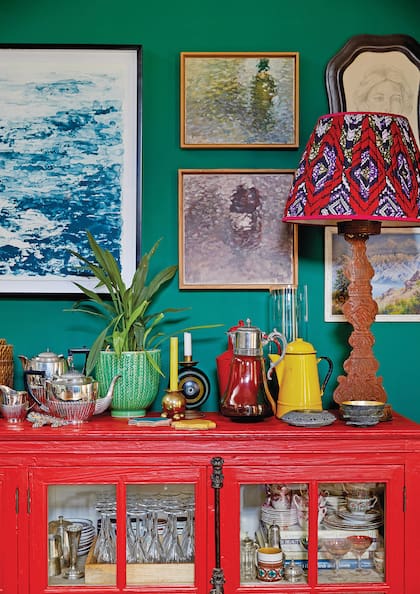 Sobre la pared verde, se destaca la pantalla hecha en un textil nigeriano también conocido como Ankara.