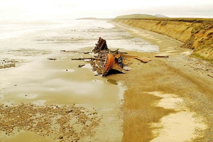 Sobre la playa se ven los restos oxidados del Desdémona, un buque naufragado en 1985