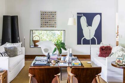 En el living, mesa baja de madera de lenga con libros de arte y diseño, esculturas de animales y trozos de árbol lavados por el mar.
