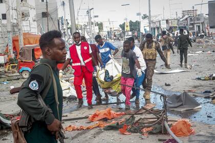 Socorristas sacan un cadáver de la escena de dos explosiones de coches-bomba en la capita de Somalia el sábado, 29 de octubre del 2022. Al menos 30 personas murieron en las explosiones, dijeron las autoridades. (AP Foto/Farah Abdi Warsameh)