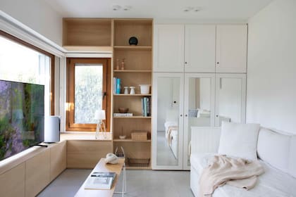 Sofá-cama de 2,30x1,80m (a medida, Kasadesign). Mesa de centro (La Feliz). Mueble de TV y biblioteca de guatambú (BHY Arquitectos), acoplados al placard existente, que llevaron de 5 a 3 módulos.