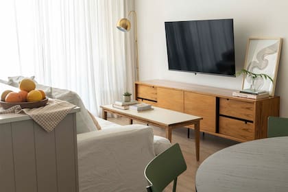 Sofá con funda de tussor offwhite, mesita entelada (Mínima huella) y mueble enchapado con patas de hierro (Marini estudio).