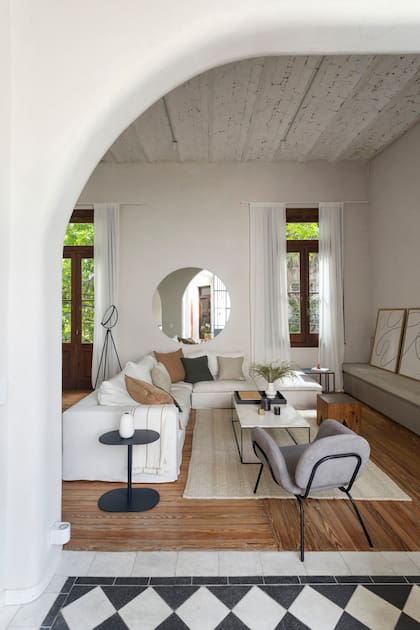 Sofá en L a medida (Estudio Simple Arquitectura), con fundas para convivir con las mascotas de la casa y almohadones en consonancia con los colores de los pisos.