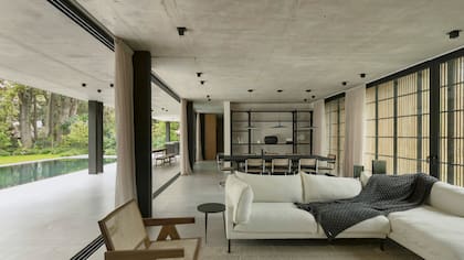 Sofá en L (Landmark). Al fondo, mesa de comedor (Casa Brava). Lámparas colgantes (Espacio Iluminación).