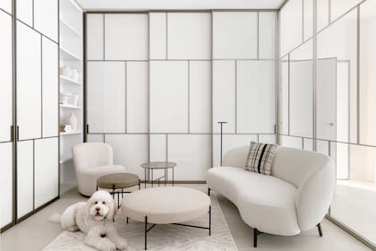 Sofá 'Lunam', diseño de Patricia Urquiola (Kartell), mesita y poufs de la colección 'Sen' (los tres, DePadova) y lámpara de pie 'Oblique' (Flos). El Aussie Labradoodle, compañero fiel de la dueña en esta aventura.