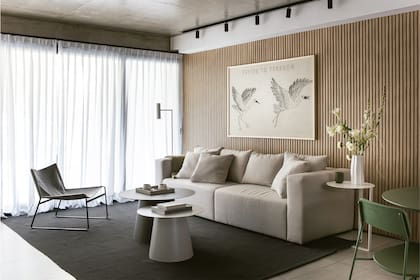 Sofá (Page y Faena) tapizado con género resistente con tratamiento antimanchas (LB Géneros). Mesa de arrime (Good Luck), lámpara de pie (Iluminación Agüero), cortinas (Tecnodesign). Mesas de centro y sillón (Cúmulo). Alfombra (RUGit). Riel con cilindros negros (Eurolamp).