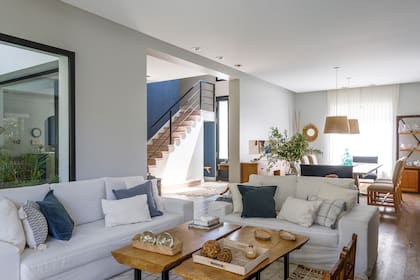 Sofás (Living Design BA). Mesas de centro con tapa de zoita y patas de hierro, sillas materas, almohadones, alfombra y cortinas de gasa (Ritta Estudio).