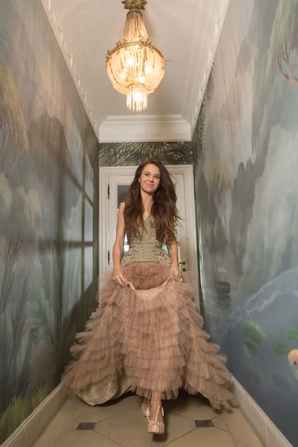 Sofía avanza por uno de los pasillos de su casa, que tiene las paredes
decoradas con sus papeles.
