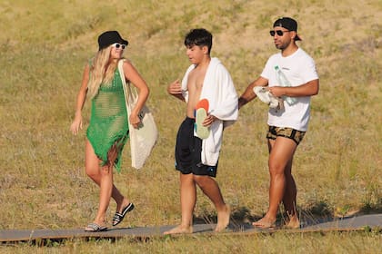 Sofía –con vestido de red, ojotas Chanel y bolso con sus iniciales–, Benja y Kun -con traje de baño Versace-, luego de un día de playa.