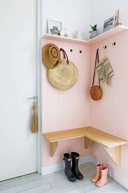 Sofía Díaz de Vivar, dueña de casa y creadora de Belgika Home, aprovechó un rincón junto al lavadero para hacer un mudroom. Lo hizo ranurado y laqueado en rosa con banco en melamina de roble natural (Dwell).