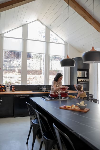 Sofía junto a su hija. Isla-mesa de Neolith 'Quarzo' (Arq. Tulio Rossini) con anafe integrado. Ollas (Lafont). Sillas 'Tolix'. Lámparas colgantes (Mercado Libre).