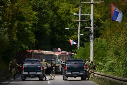 Soldados de la OTAN que prestan servicio en Kosovo patrullan junto a una barricada de carretera levantada por personas de etnia serbia cerca de la ciudad de Zubin Potok el 1 de agosto de 2022.