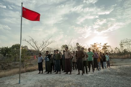 Soldados de las Fuerzas de Defensa Popular participan en una ceremonia de arriado de bandera al atardecer como parte de su entrenamiento en Anyar