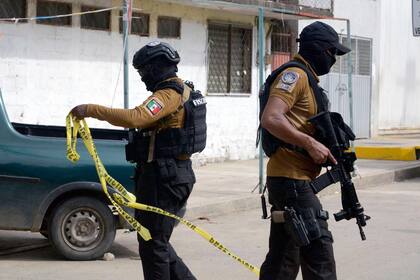 Soldados del Ejército Mexicano y miembros de la Policía Estatal revisan el área donde el periodista mexicano Nelson Mateus fue asesinado en la ciudad turística de Acapulco, estado de Guerrero, México, el 15 de julio de 2023. (foto por: FRANCISCO ROBLES / AFP)�