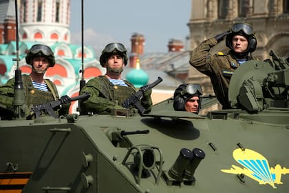 Soldados del ejército ruso se paran en un vehículo militar rodando durante un ensayo general para el desfile militar del Día de la Victoria en Moscú, Rusia, el 7 de mayo de 2022. (AP Photo/Alexander Zemlianichenko)