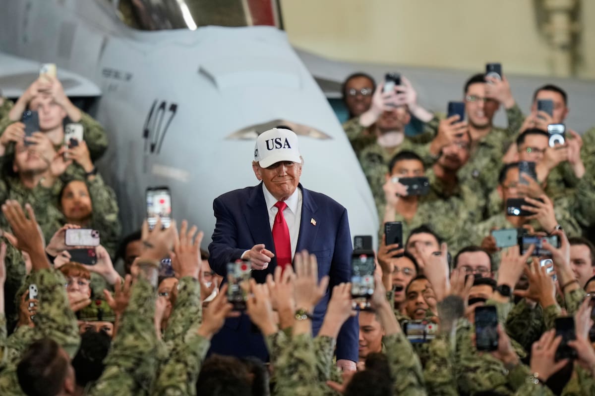 Soldados estadounidenses saludan y toman fotos con sus teléfonos al presidente Donald Trump.
