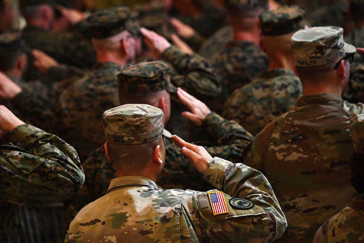 Soldados filipinos y estadounidenses saludan delante de sus banderas nacionales mientras suenan sus himnos nacionales durante la ceremonia de apertura del ejercicio militar conjunto "Balikatan" en el cuartel general militar de Quezon City, en los suburbios de Manila, el 11 de abril de 2023.