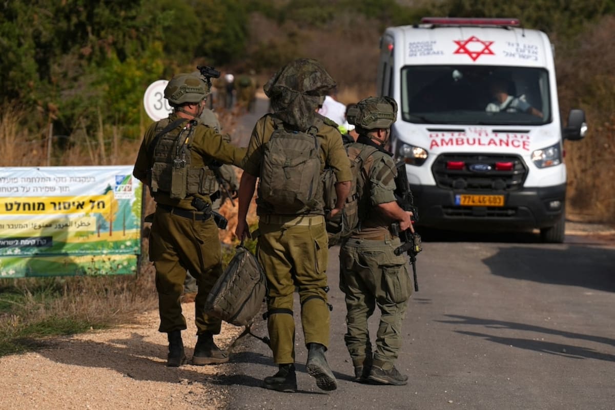 Soldados israelíes junto a una ambulancia en la zona donde se produjo hoy la explosión durante una excursión escolar, cerca de Kiryat Shmona, en el norte de Israel,