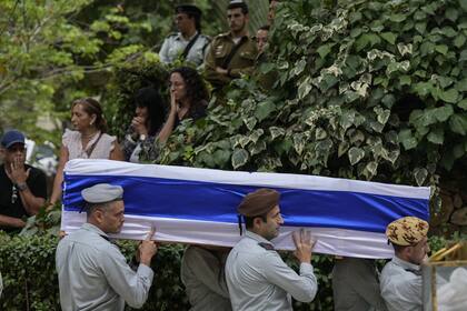 Soldados israelíes llevan el ataúd cubierto con la bandera del Coronel Roi Levy durante su funeral en el cementerio del Monte Herzl en Jerusalén el lunes 9 de octubre de 2023.