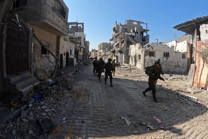 Soldados israelíes patrullan una zona de Gaza destruida por los bombardeos