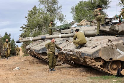 Soldados israelíes realizan mantenimiento a tanques desplegados en la frontera sur con la Franja de Gaza el 28 de noviembre de 2023