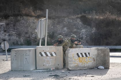 Soldados israelíes toman posiciones en un punto de control carretero cerca de la ciudad de Nablus, en el norte de Cisjordania, el sábado 24 de septiembre de 2022. (AP Foto/Majdi Mohammed)