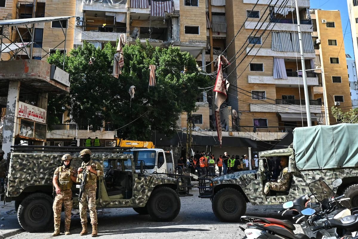 Soldados libaneses montan guardia mientras los servicios de emergencia inspeccionan los daños en el lugar de un ataque aéreo israelí contra apartamentos en un edificio residencial en los suburbios del sur de Beirut el 7 de junio de 2026